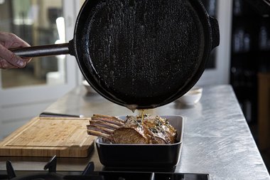 Pour the cooking liquid over the Frenched rack.