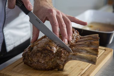 Carve the Frenched veal rack into slices.