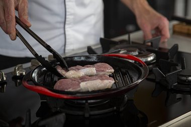 Place the veal entrecote in the pan.