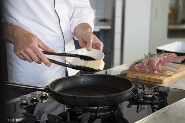 Put the butter in the pan for the Frenched veal rack..