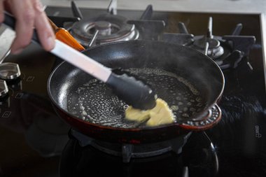 Spread the butter in the pan.